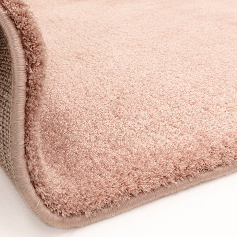 pink plain shaggy rug partial fold on white floor