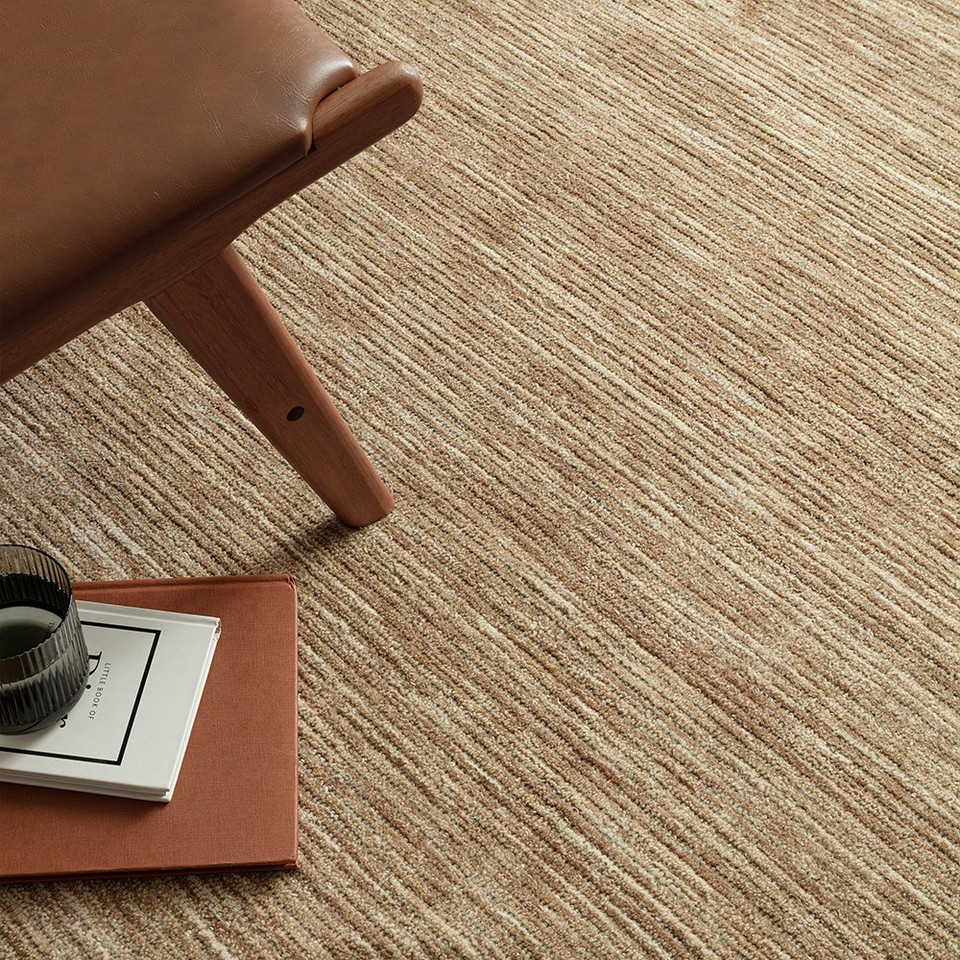 beige plain rug closeup with a chair