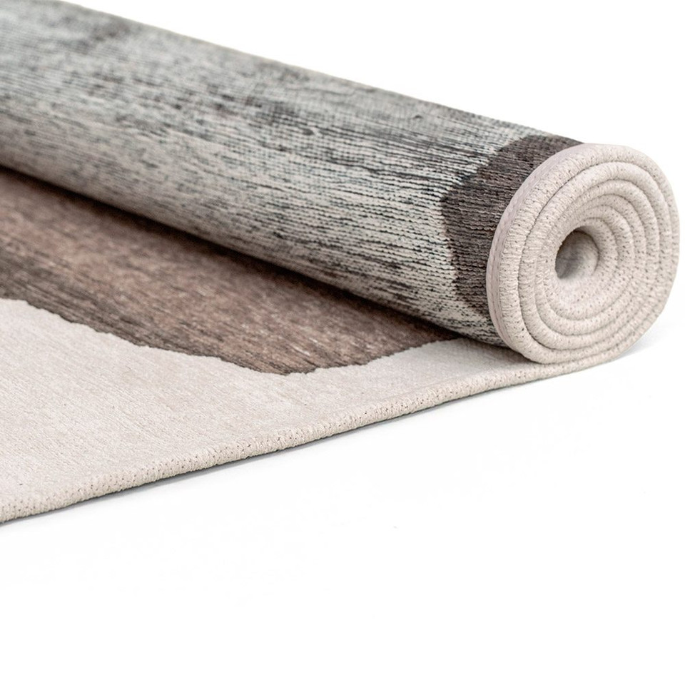 mastic abstract eco rug partially rolled on a white floor