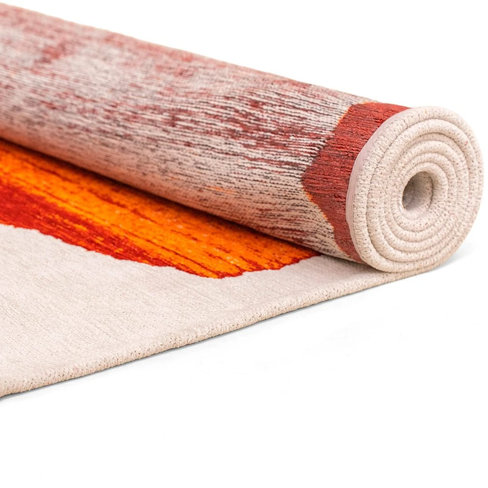 orange abstract eco rug partially rolled on a white floor