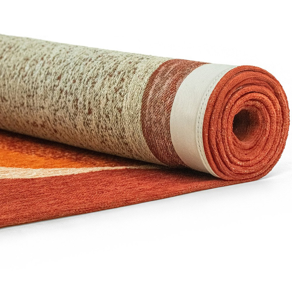 orange abstract eco rug partially rolled on a white floor