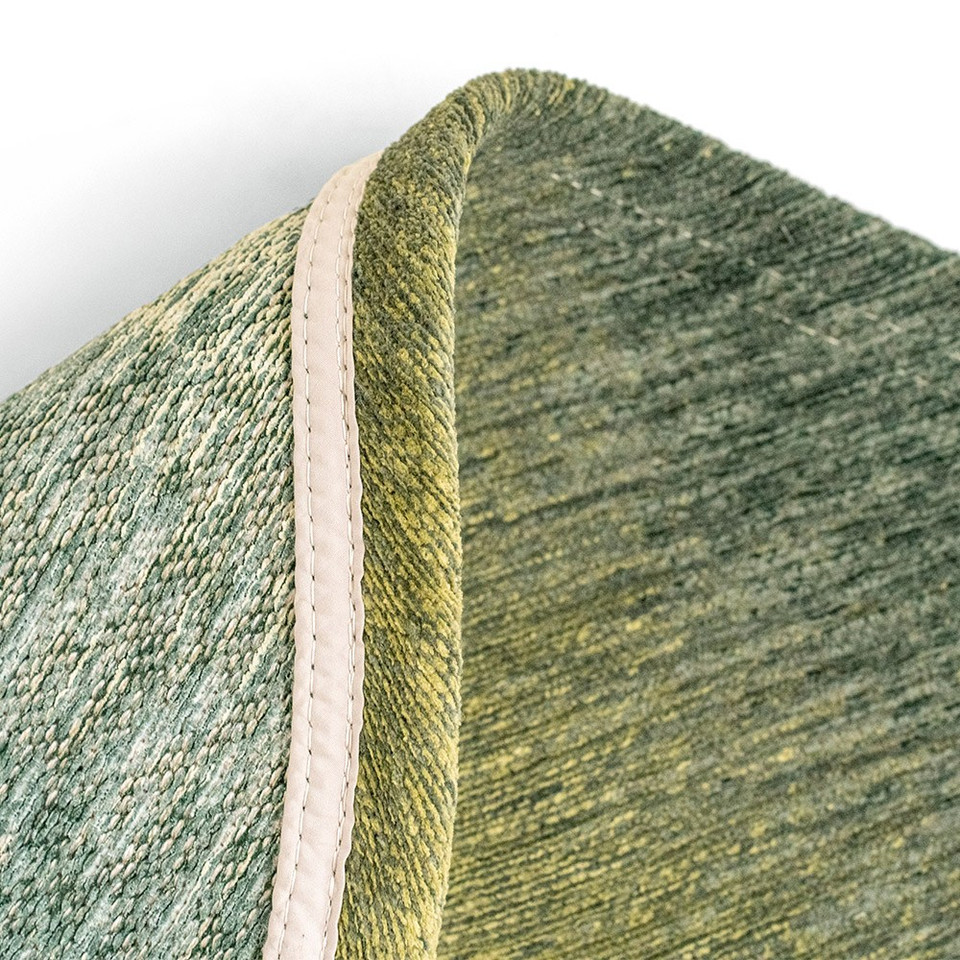 green peanut shape rug folded on white floor