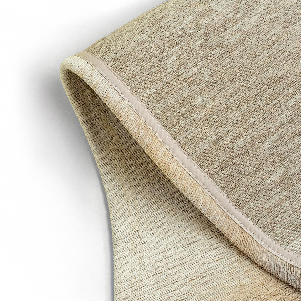 beige peanut shape rug folded on white floor