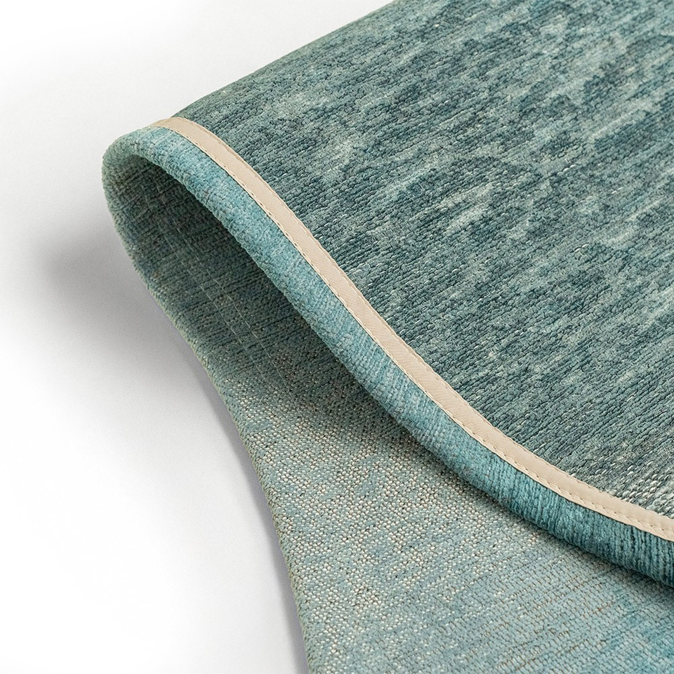 blue peanut shape rug folded on white floor