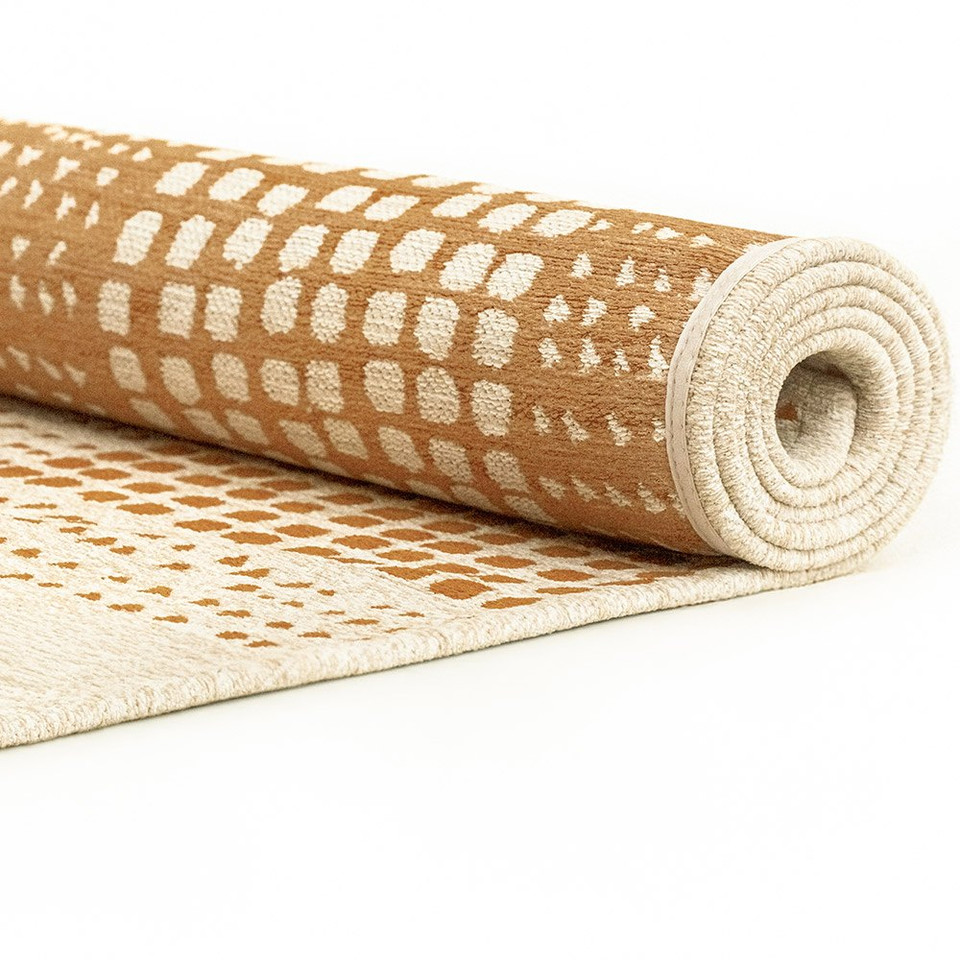 brown abstract eco rug partially rolled on a white floor