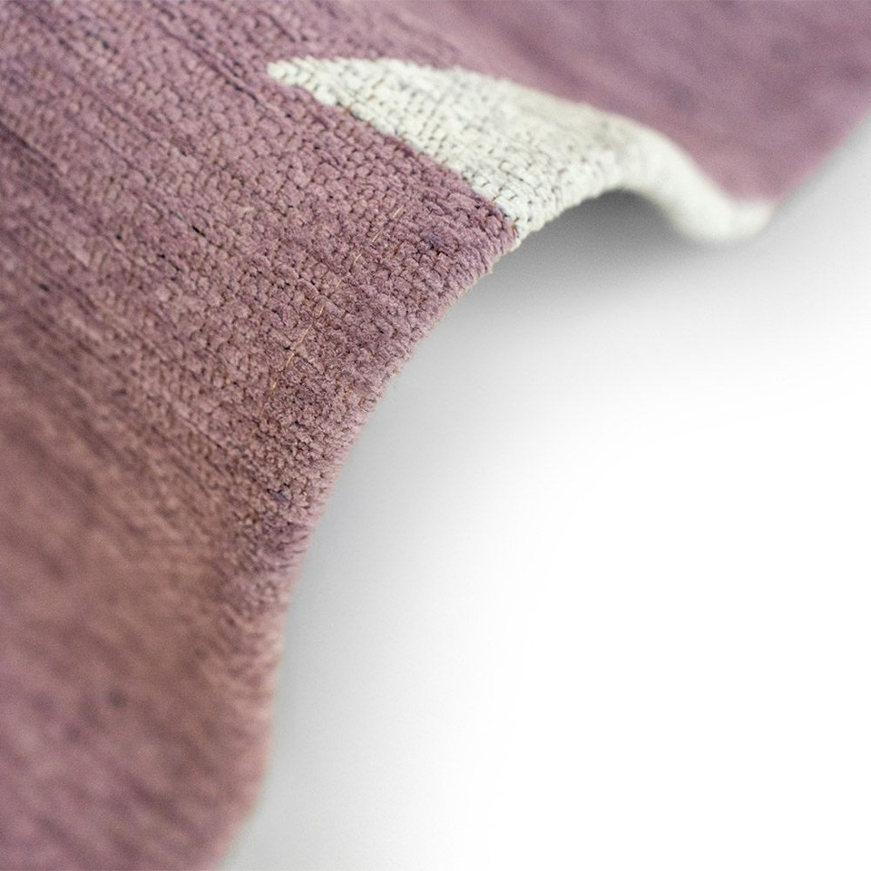 purple abstract rug folded on white floor