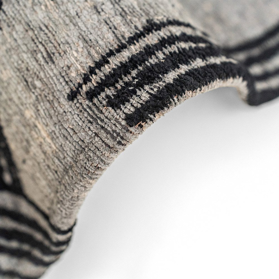 grey abstract rug folded on white floor