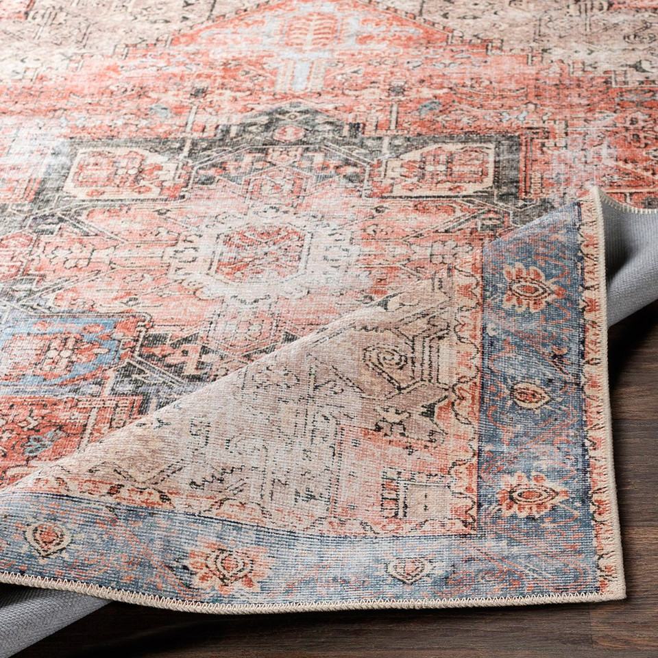 rust traditional rug folded on dark wood floor