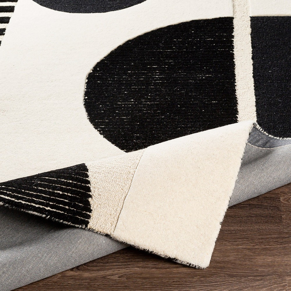 cream geo wool rug corner fold on wood floor