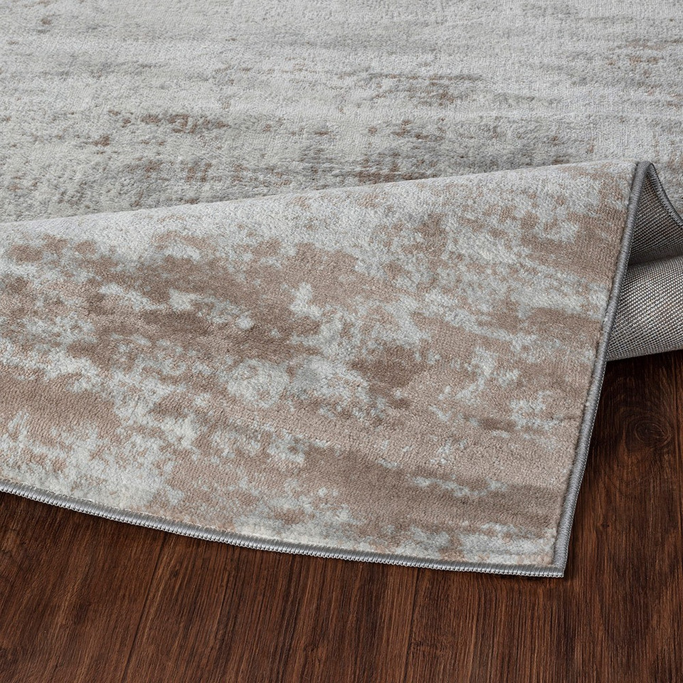 grey abstract rug folded on wood floor