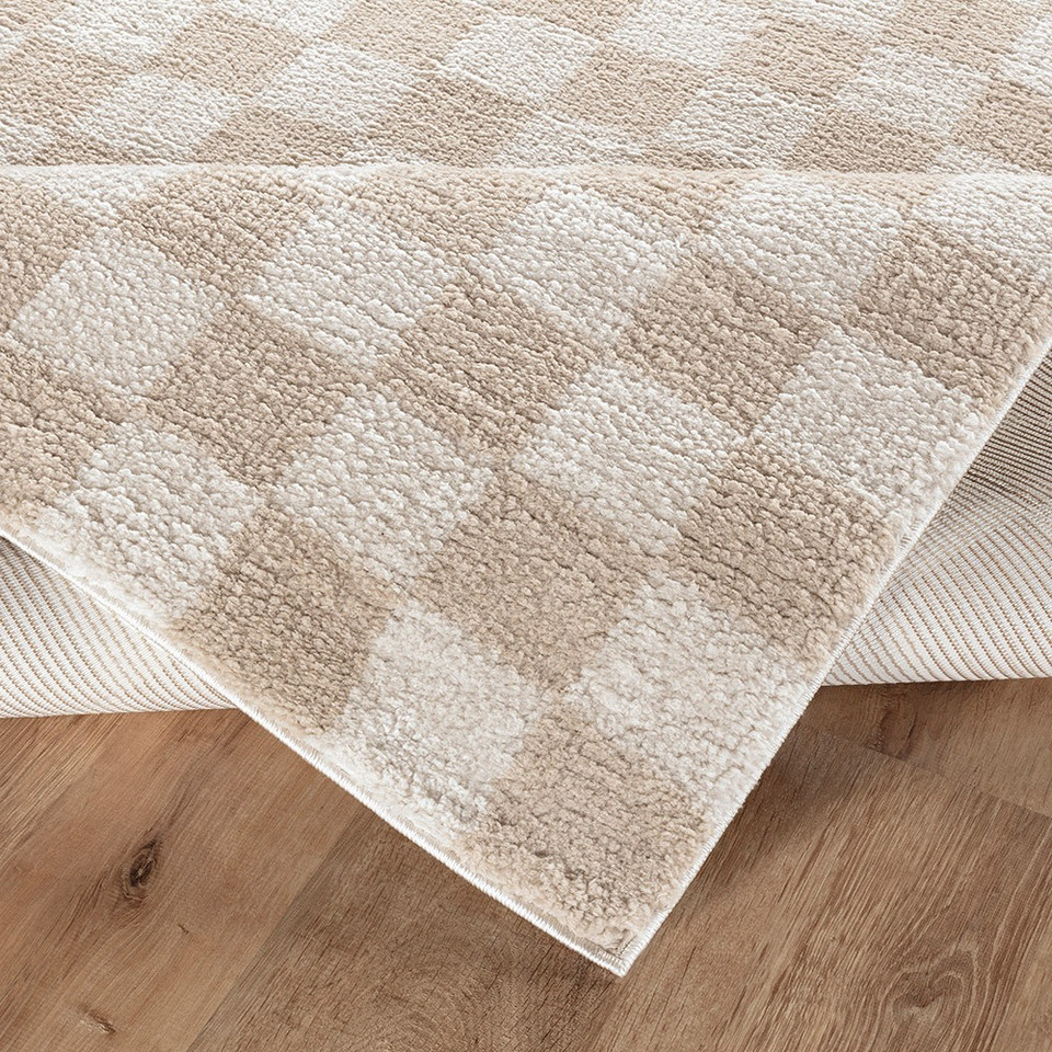 beige checker shaggy rug folded on wood floor