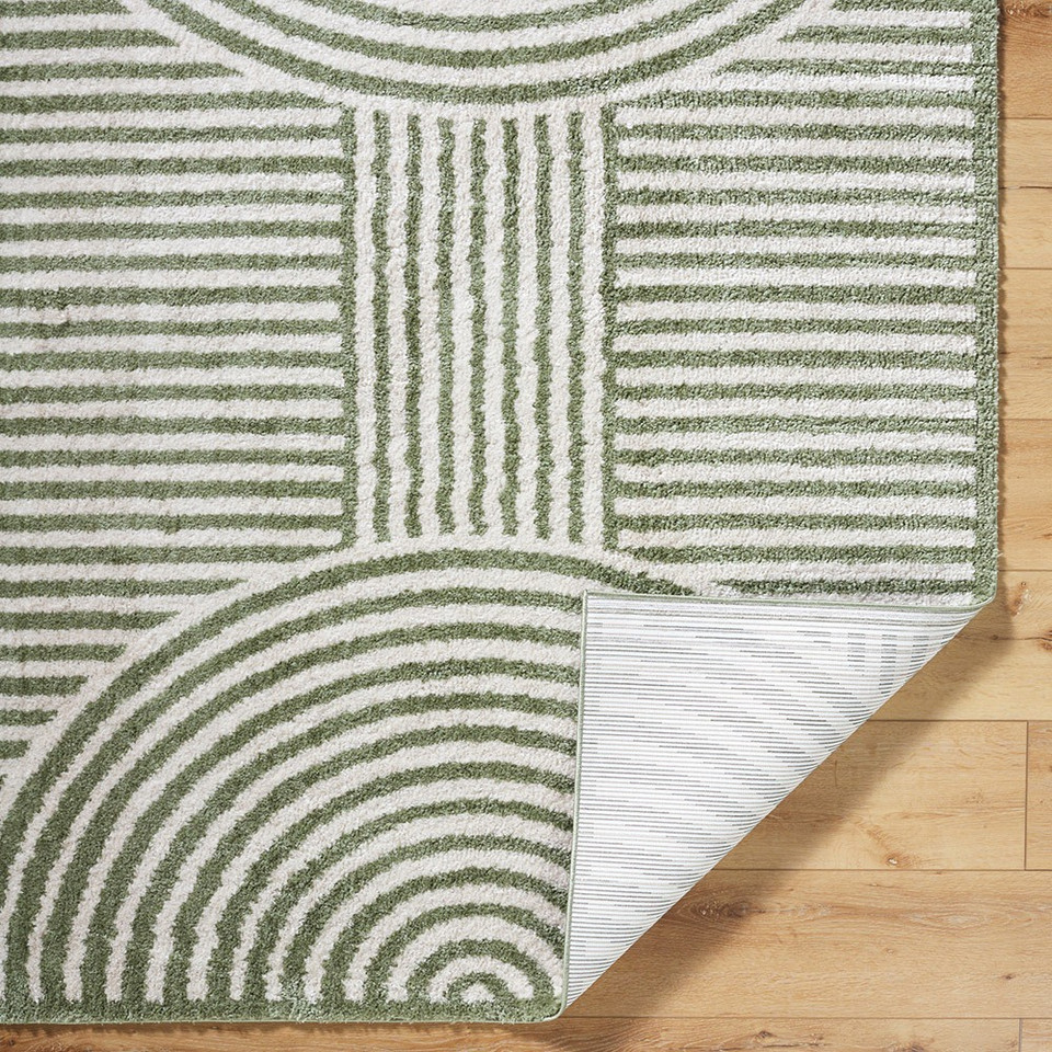 green geometric shaggy rug folded on wood floor