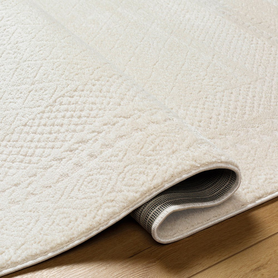 ivory off-white scandi rug folded on wood floor