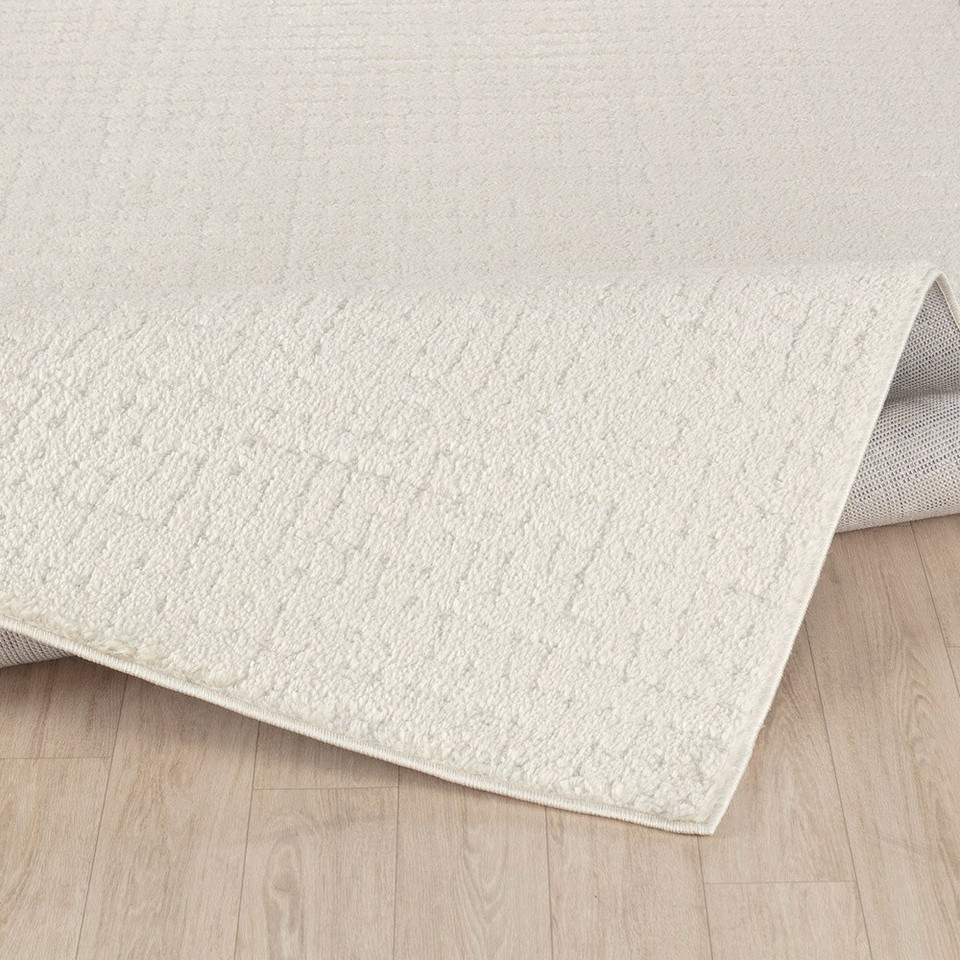 ivory off-white scandi rug folded on wood floor