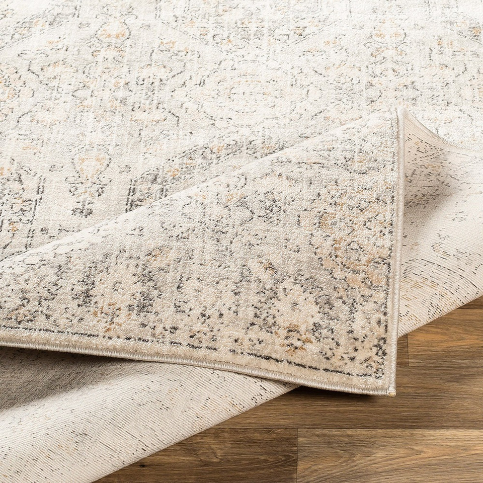 ivory traditional rug folded on wood floor