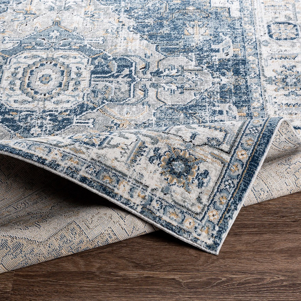 blue traditional rug folded on wood floor
