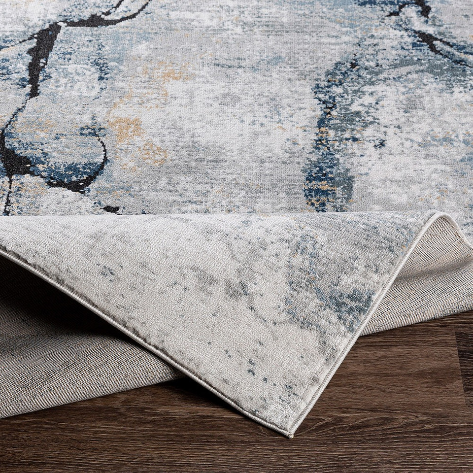 blue abstract rug folded on wood floor