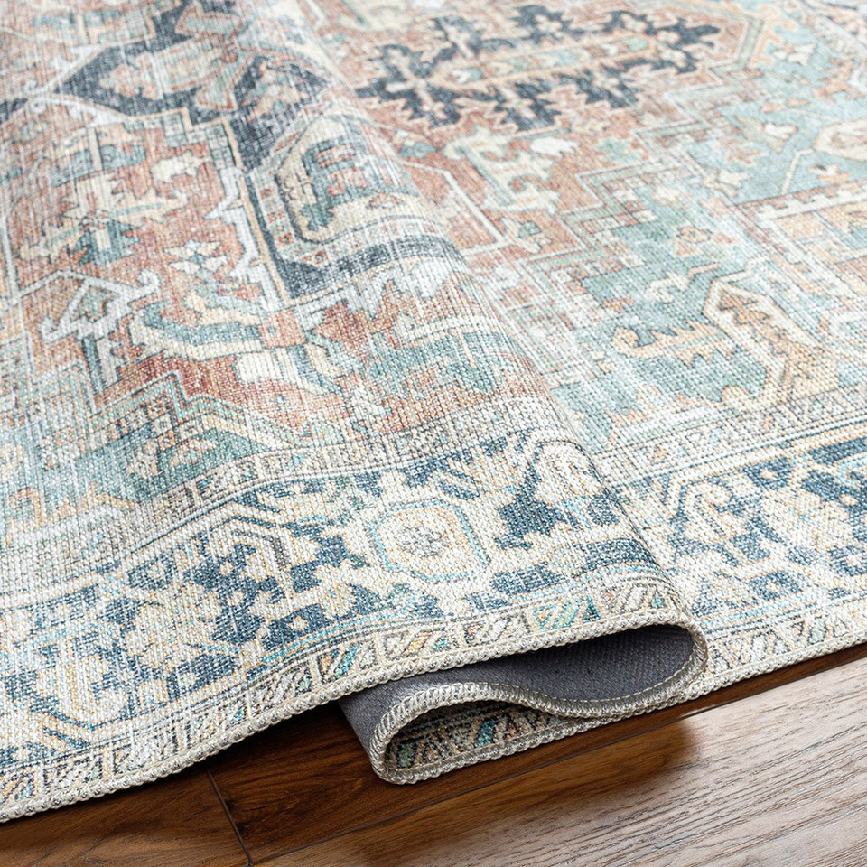 sage traditional rug folded on wood floor