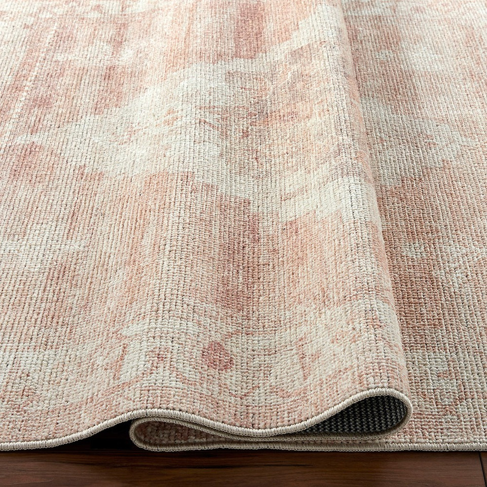 blush traditional rug folded on wood floor