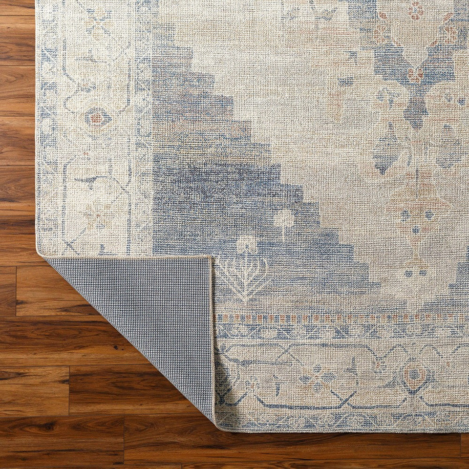navy traditional rug folded on wood floor