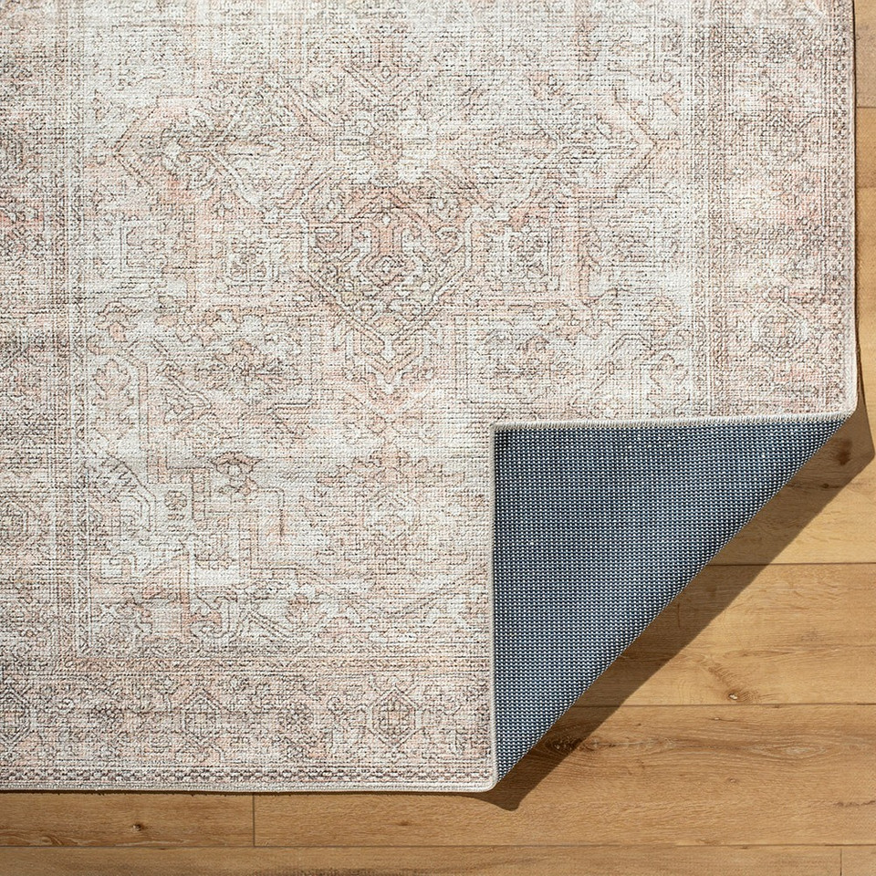 blush traditional rug folded on wood floor