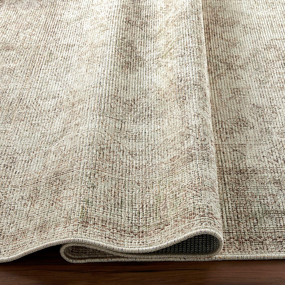 sage traditional rug folded on wood floor