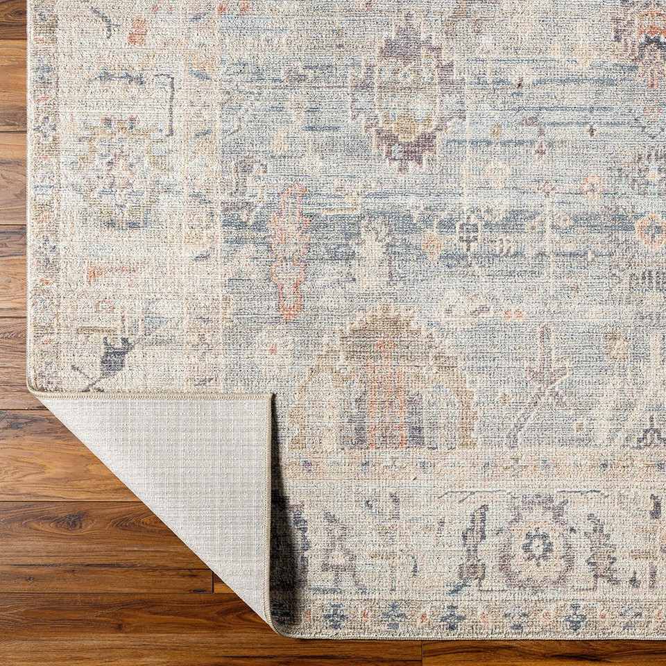 grey blue traditional rug folded on wood floor
