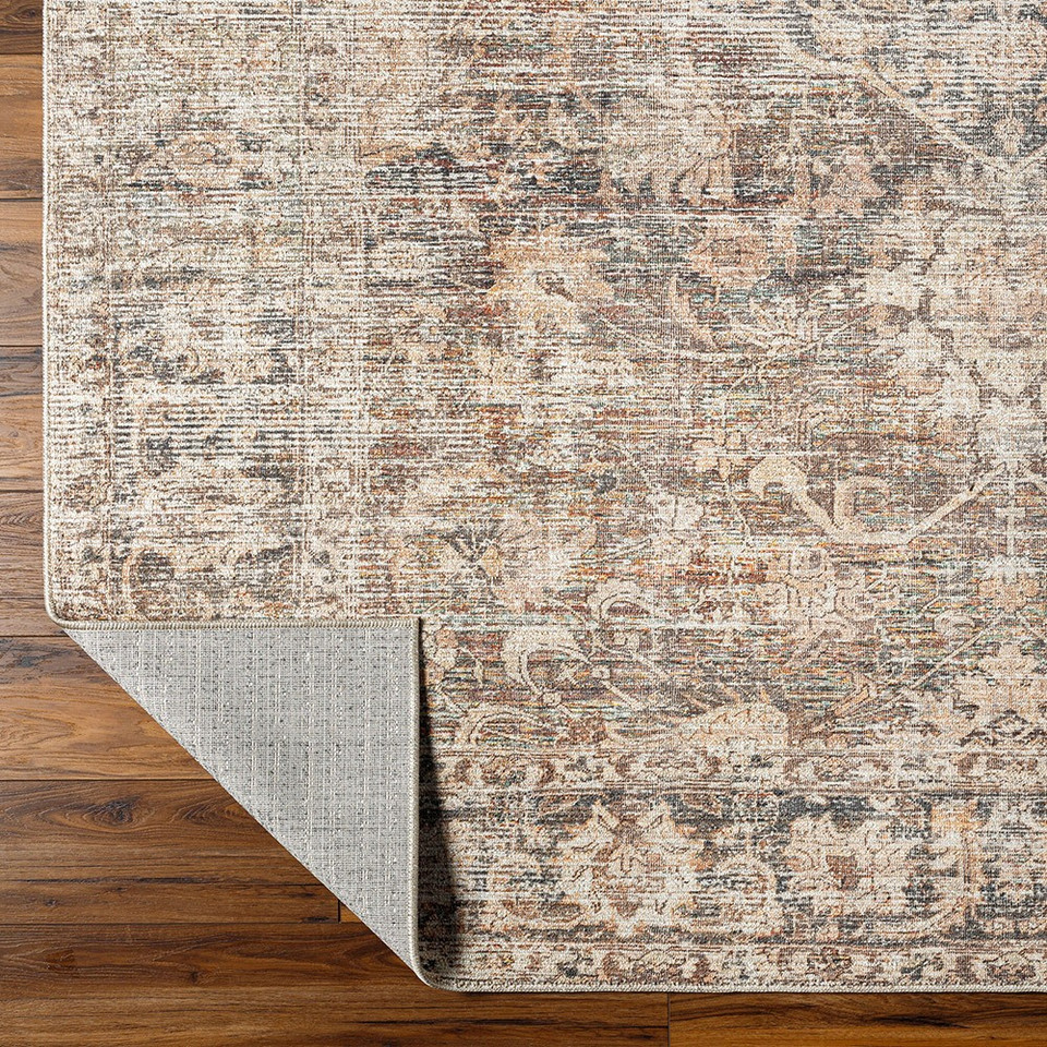 taupe traditional rug folded on wood floor