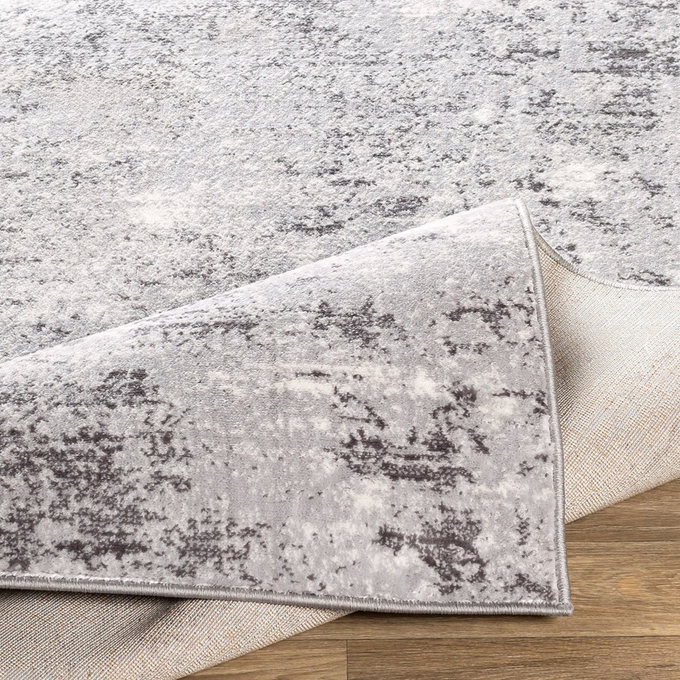 silver abstract rug corner fold on wood floor