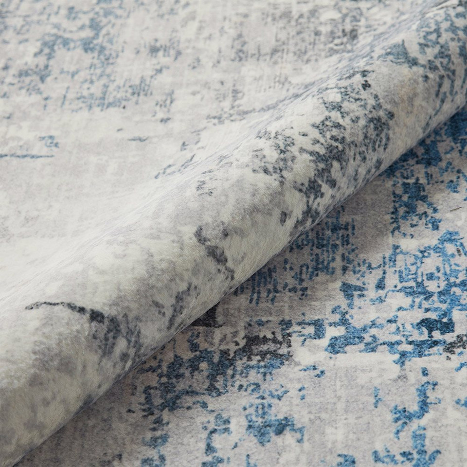 ivory blue abstract rug closeup rolled