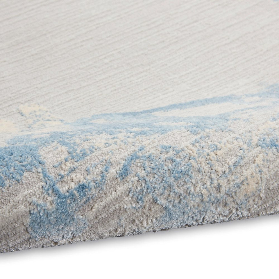 grey sky calvin klein rug partially rolled on white floor