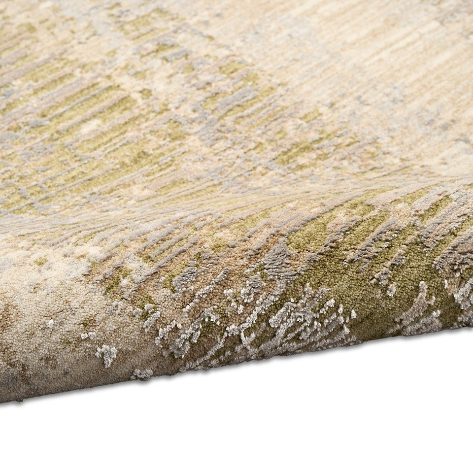 beige sage calvin klein rug partially rolled on white floor
