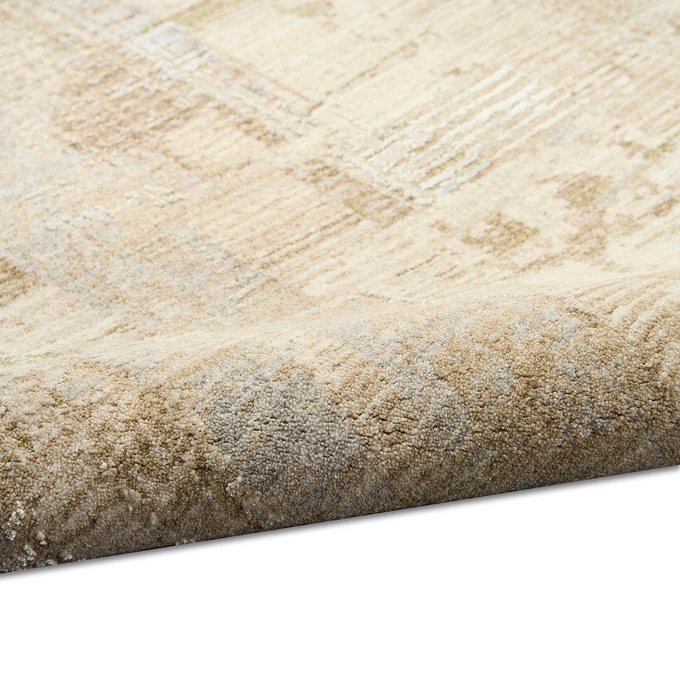 beige grey calvin klein rug partially rolled on white floor