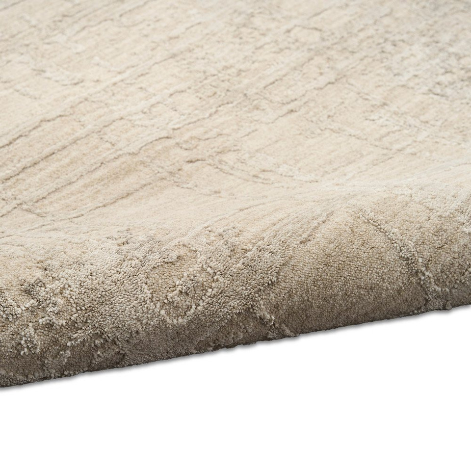 ivory beige calvin klein rug partially rolled on white floor