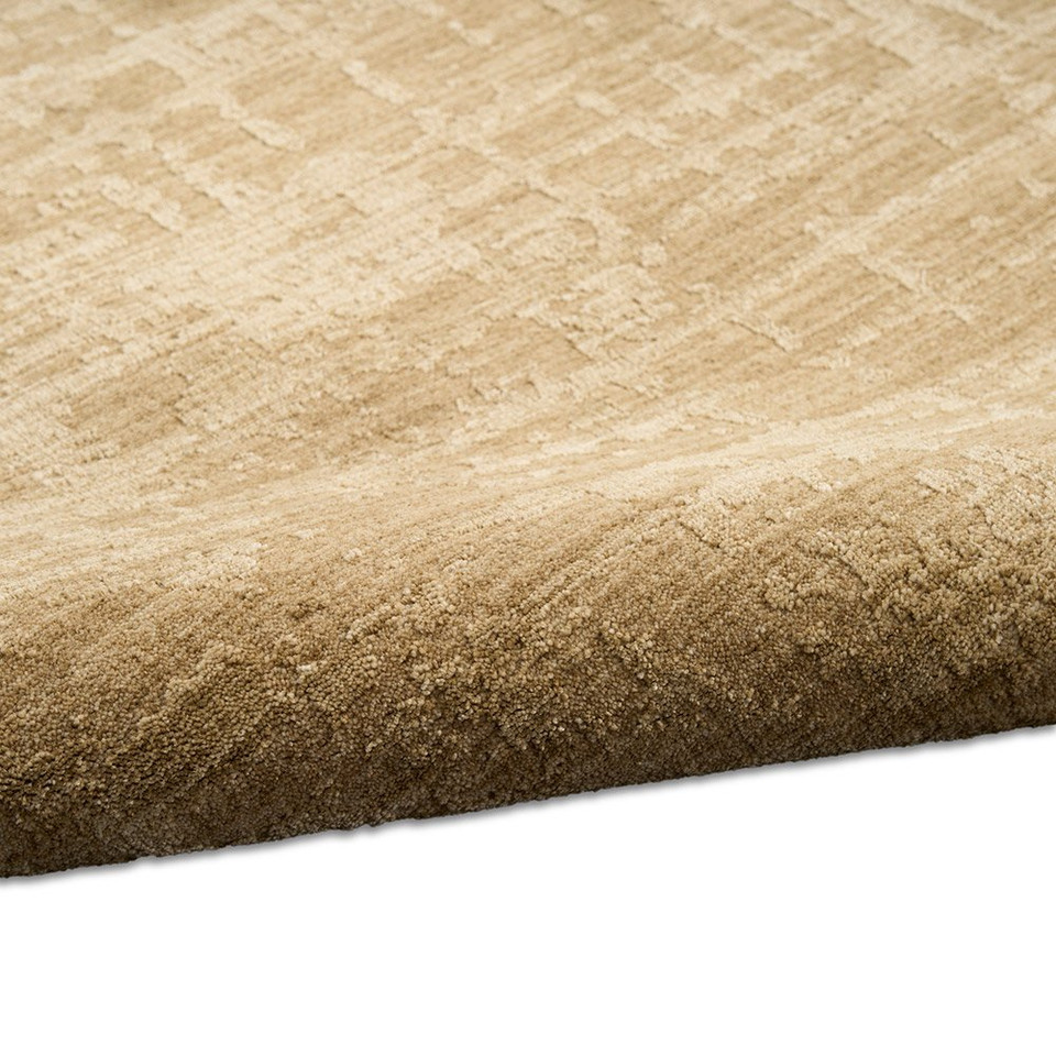 taupe calvin klein rug partially rolled on white floor