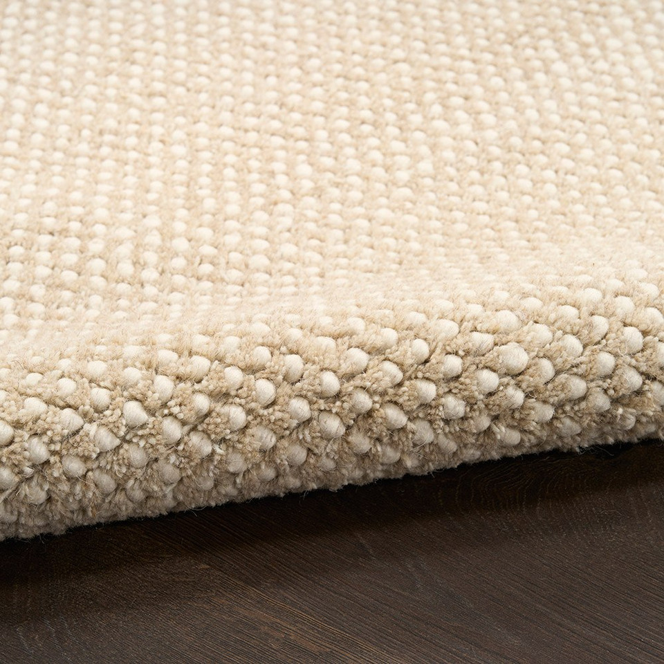 ivory taupe rug partially rolled on wood floor