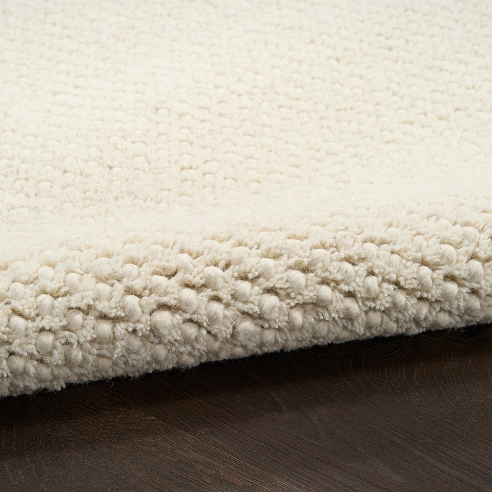 ivory rug partially rolled on wood floor