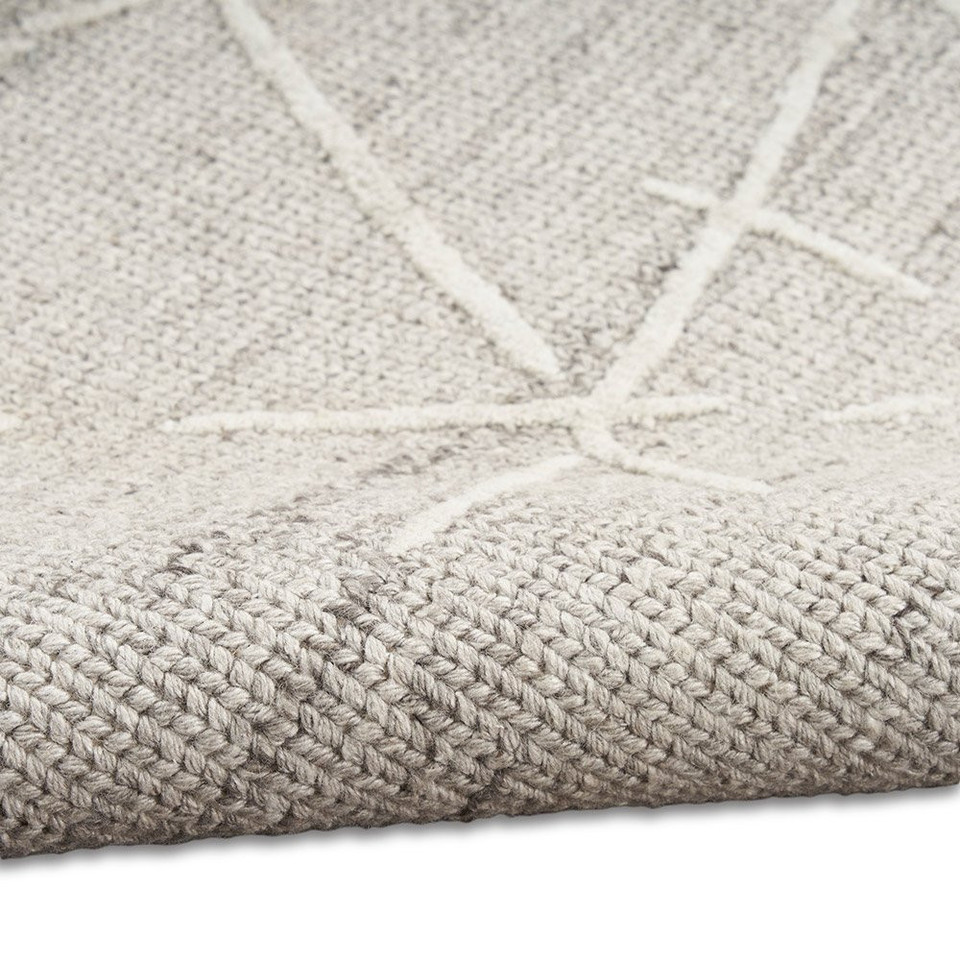 grey calvin klein rug partially rolled on white floor
