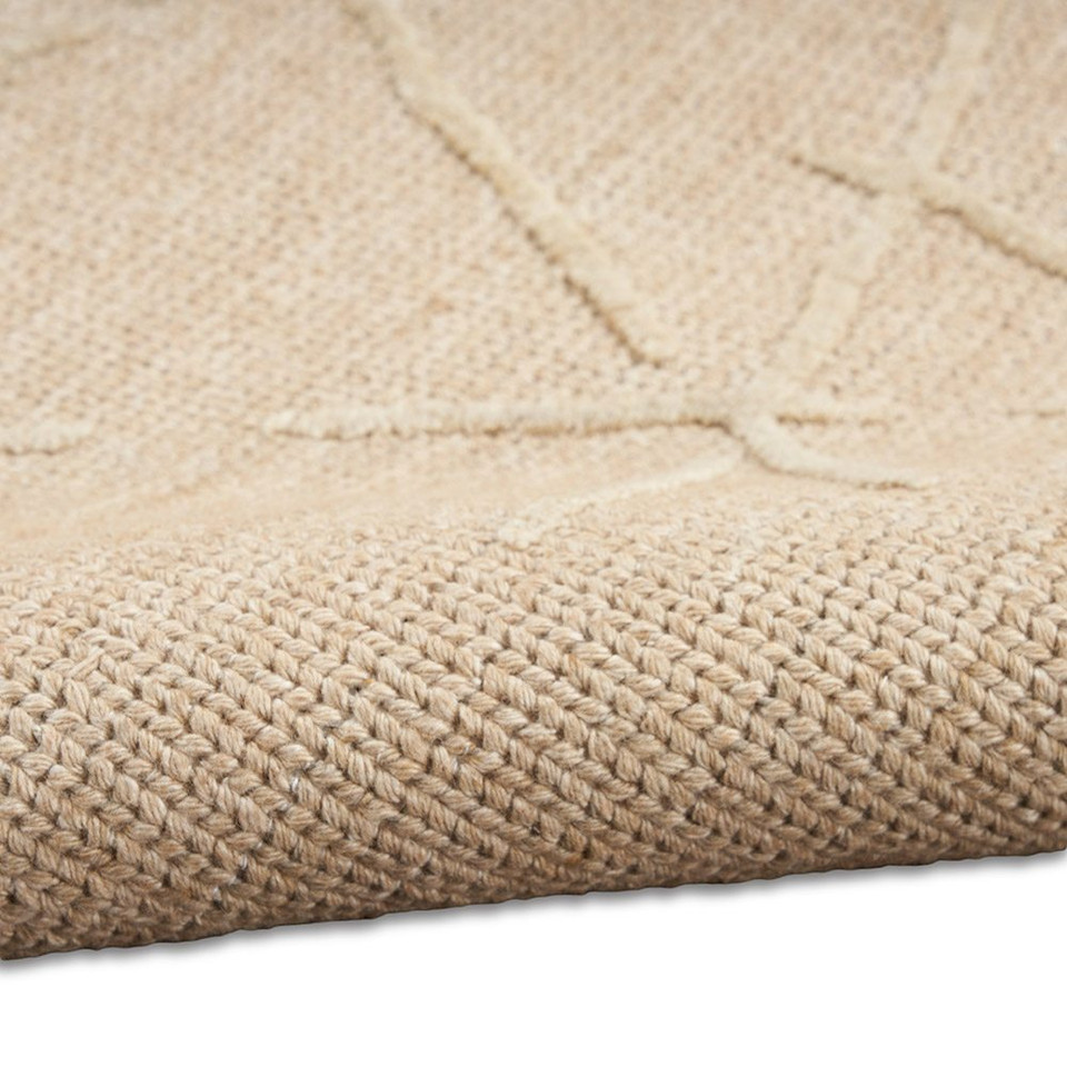 natural calvin klein rug partially rolled on white floor