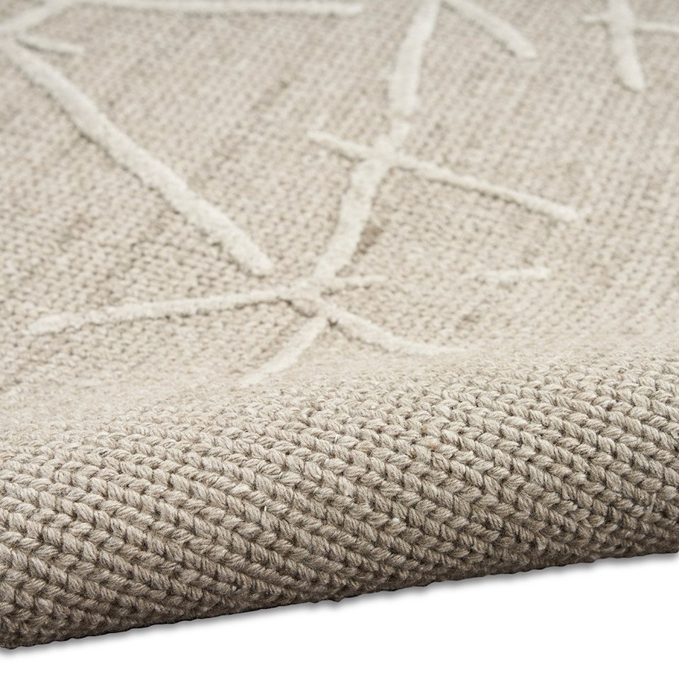 taupe calvin klein rug partially rolled on white floor