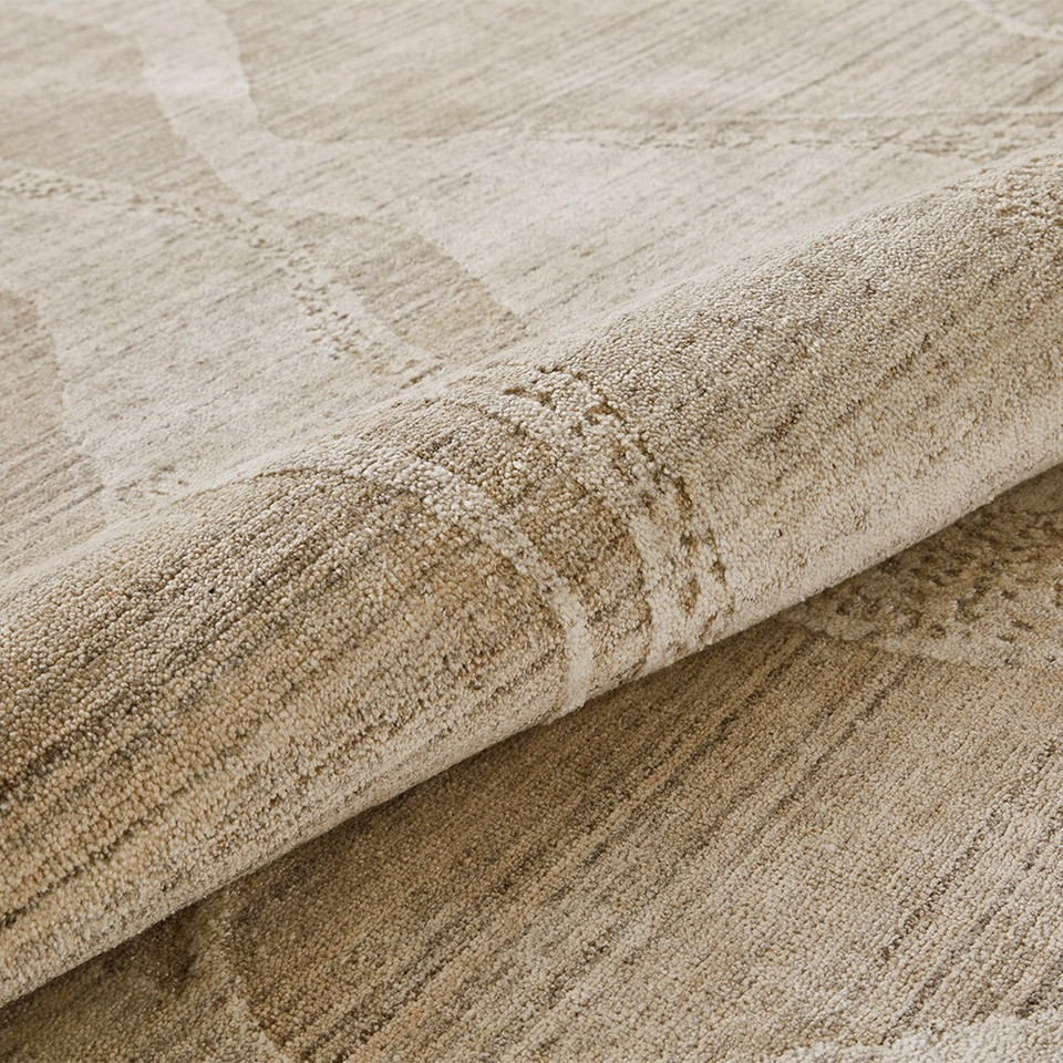 beige abstract rug closeup partially rolled