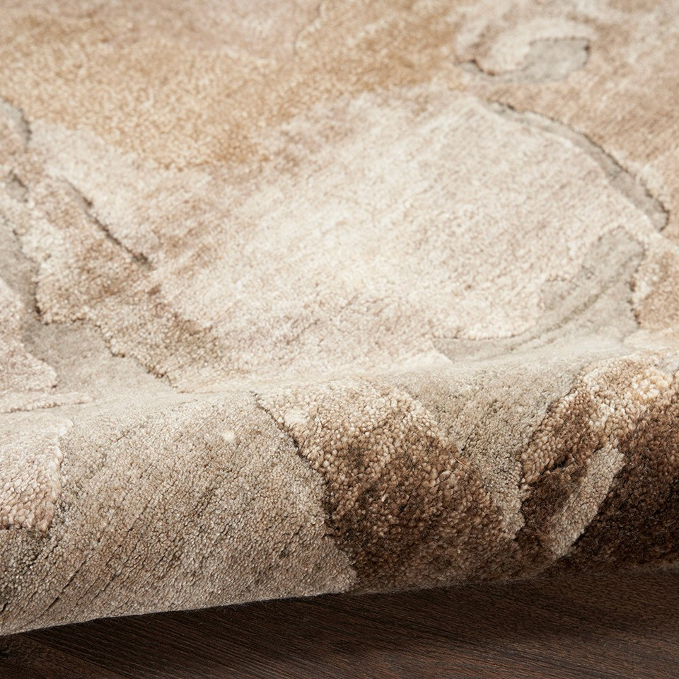 beige silver abstract rug partially rolled on wood floor