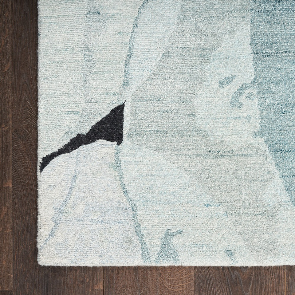 blue pink abstract rug closeup corner on wood floor