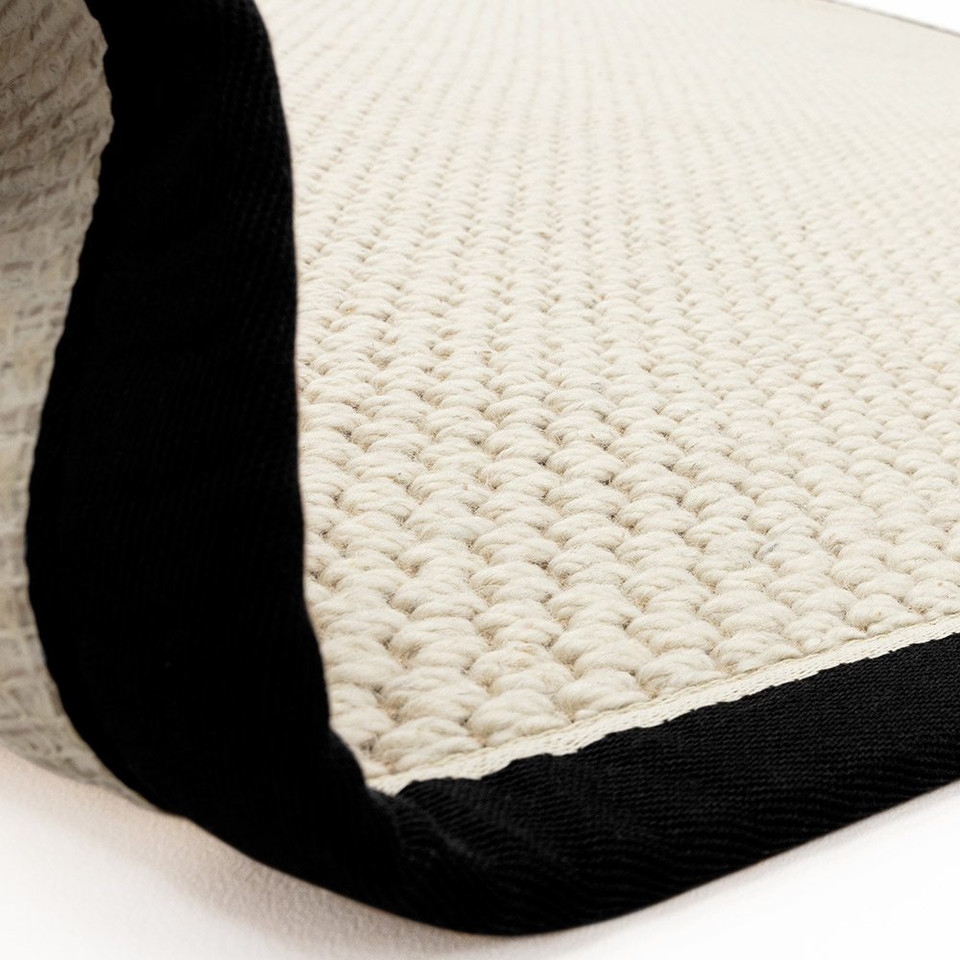 cream wool jute rug partial fold on white floor