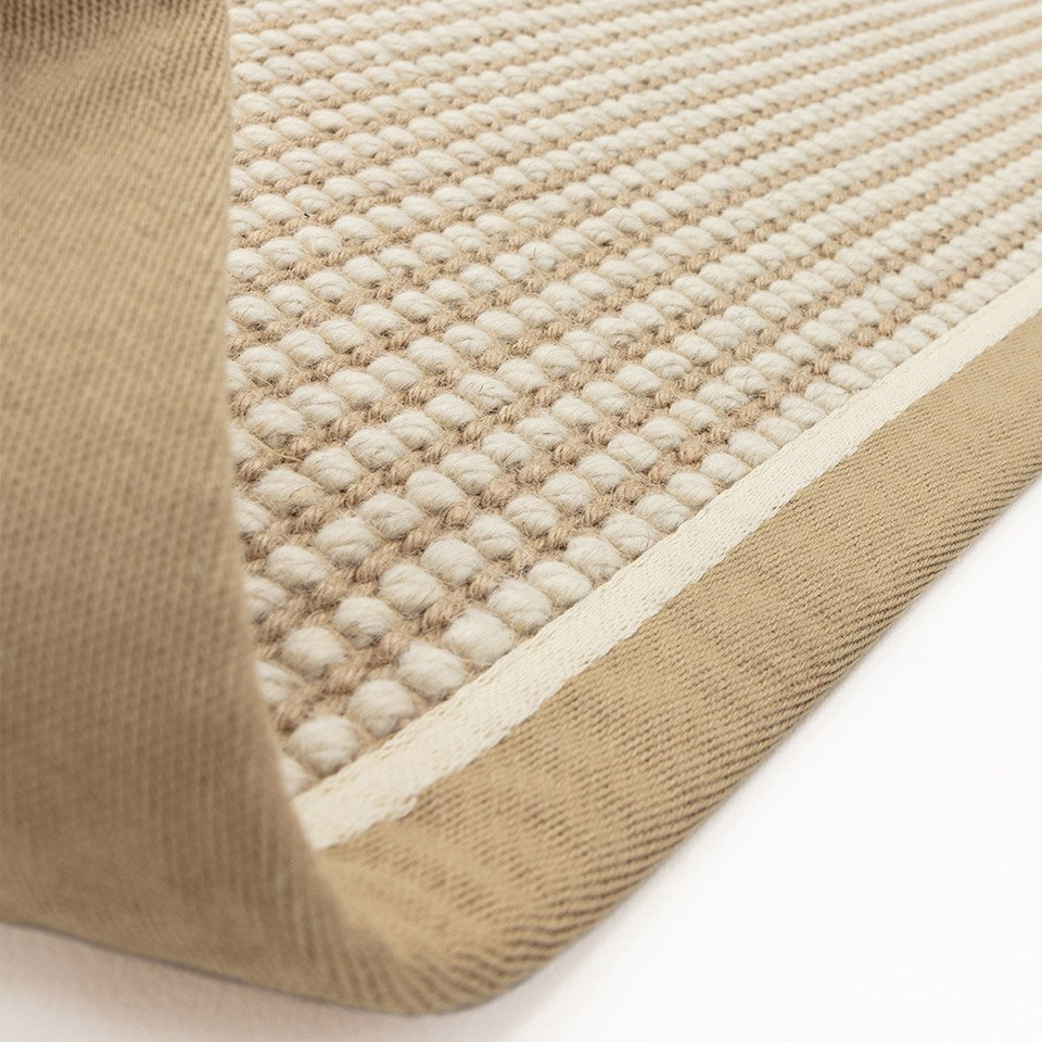 cream wool jute rug partial fold on white floor
