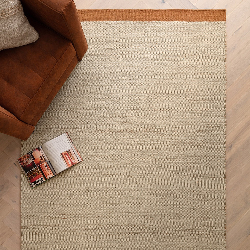 rust flatweave wool rug in a living room with matching decor