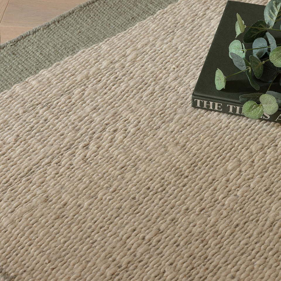 sage flatweave wool rug closeup border with book