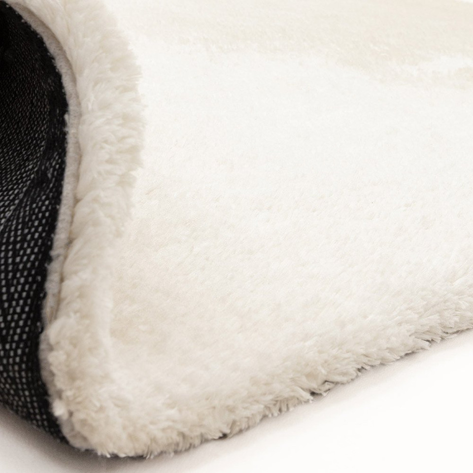ivory shaggy rug partial fold on white floor