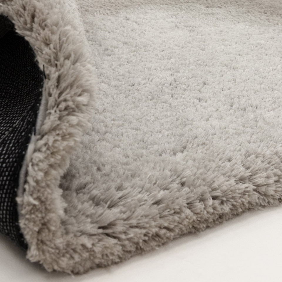 silver shaggy rug partial fold on white floor