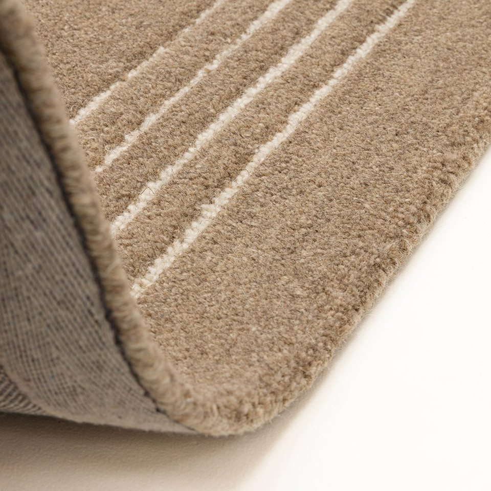 A folded corner of the Orlo cocoa brown wool rug, showcasing the premium woven backing and deep pile thickness.